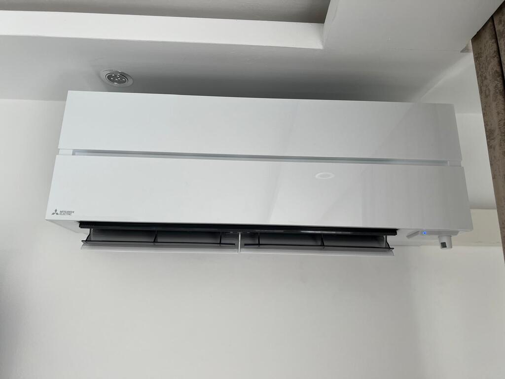 Klimaanlage an weißer Wand, moderner Stil, glänzend, rechteckige Form.
